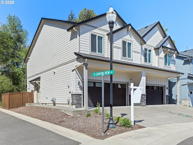 2421 S Trail View Ct, Ridgefield, WA 98642 - view of front of house with concrete driveway, an attached garage, fence, and stone siding