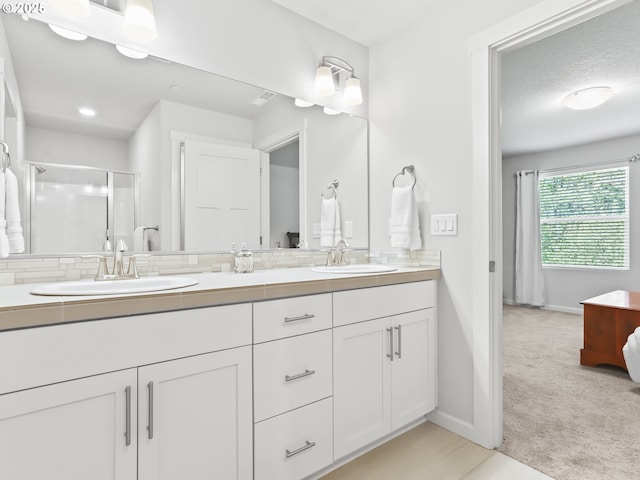 2421 S Trail View Ct, Ridgefield, WA 98642 - bathroom featuring double vanity, baseboards, a shower stall, and a sink