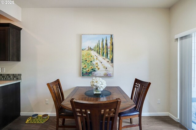 dining space featuring baseboards and dark wood finished floors