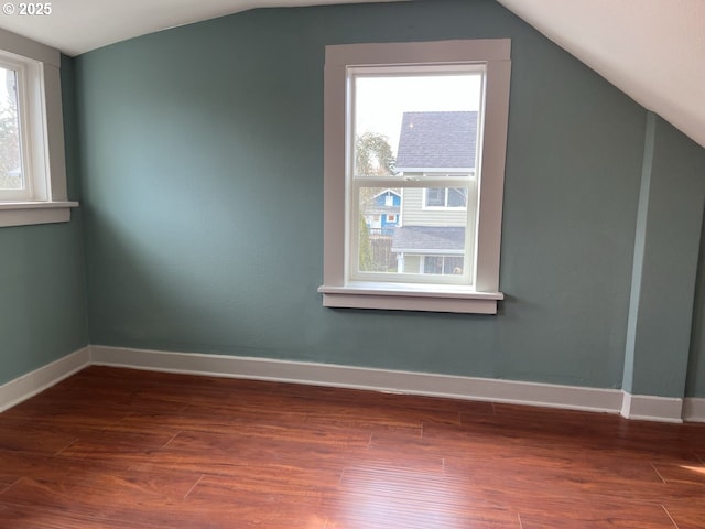 bonus room with lofted ceiling, baseboards, wood finished floors, and a healthy amount of sunlight