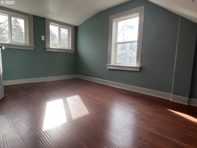 bonus room with dark wood-style floors, baseboards, vaulted ceiling, and a wealth of natural light