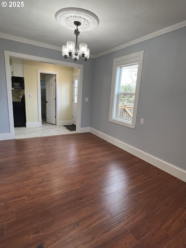 empty room featuring light wood-type flooring, an inviting chandelier, and ornamental molding