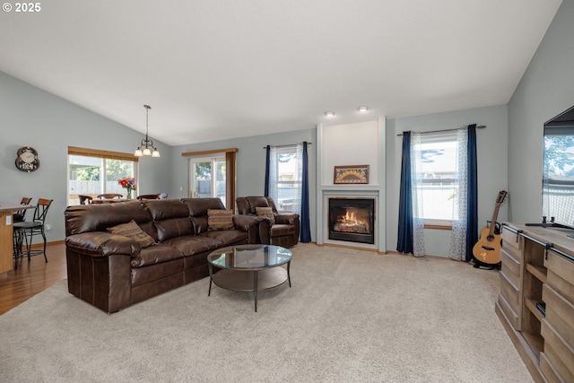 33447 SW Sequoia St, Scappoose, OR 97056 - living area with vaulted ceiling, a glass covered fireplace, light carpet, and a chandelier