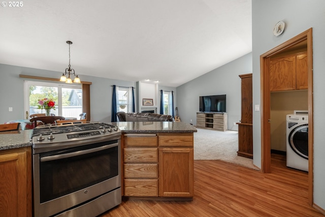 33447 SW Sequoia St, Scappoose, OR 97056 - kitchen with washer / dryer, gas stove, light wood-style floors, open floor plan, and lofted ceiling