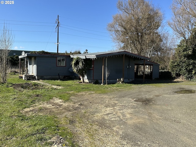 rear view of house featuring dirt driveway and crawl space