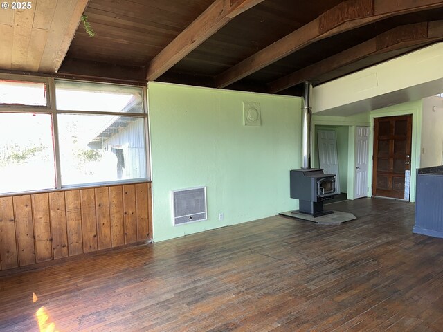 unfurnished living room with wooden ceiling, beam ceiling, hardwood / wood-style floors, and a wood stove