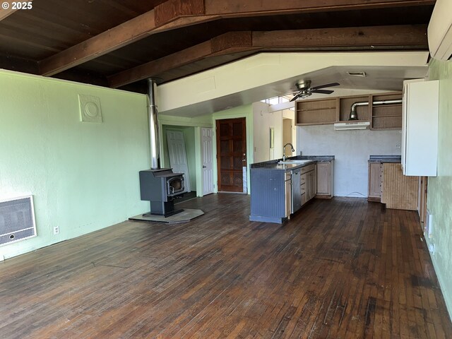 kitchen featuring heating unit, a sink, dark wood-type flooring, stainless steel dishwasher, and dark countertops