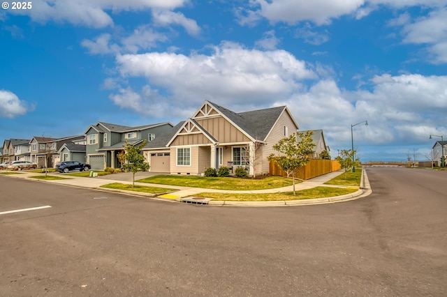 view of front of home featuring board and batten siding, fence, and a residential view