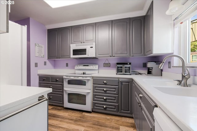1650 NW Lakeway Ln, Beaverton, OR 97006 - kitchen featuring white appliances, a sink, gray cabinets, light countertops, and light wood finished floors