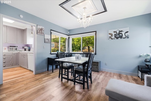 1650 NW Lakeway Ln, Beaverton, OR 97006 - dining room with a chandelier, light wood-style floors, and baseboards