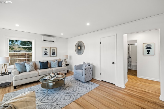 living area with baseboards, a wall unit AC, wood finished floors, and recessed lighting