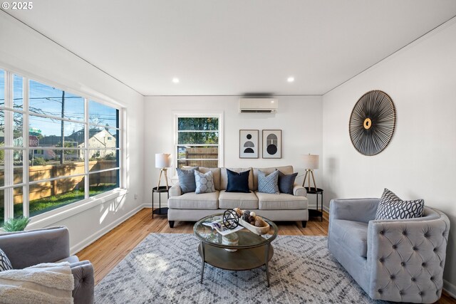 living area featuring recessed lighting, baseboards, an AC wall unit, and wood finished floors