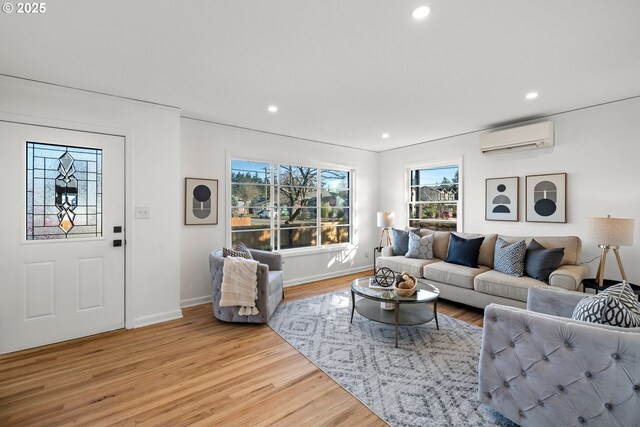 living room with light wood-style floors, recessed lighting, baseboards, and a wall mounted AC