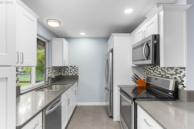 17954 NW Andria Ave, Portland, OR 97229 - kitchen with stainless steel appliances, a sink, white cabinetry, recessed lighting, and baseboards