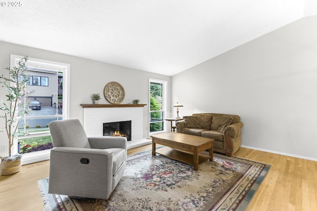 767 SW 8th St, Gresham, OR 97080 - living area with wood finished floors, a lit fireplace, vaulted ceiling, and baseboards