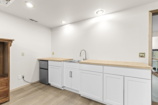 767 SW 8th St, Gresham, OR 97080 - kitchen featuring wooden counters, a sink, light wood-style flooring, stainless steel fridge, and white cabinets