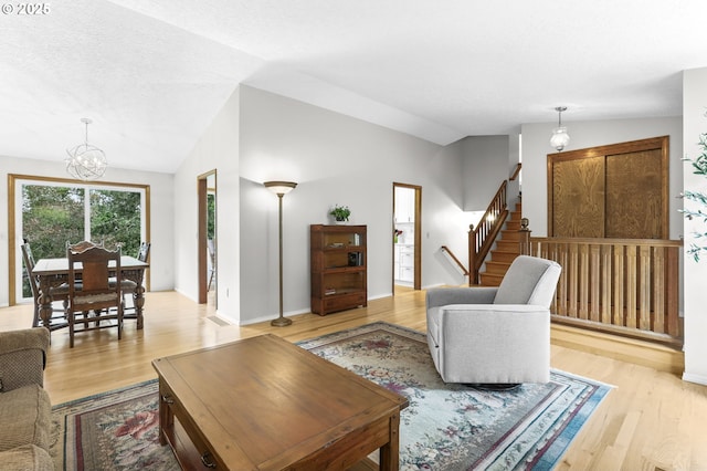 767 SW 8th St, Gresham, OR 97080 - living room with vaulted ceiling, wood finished floors, stairs, a chandelier, and baseboards