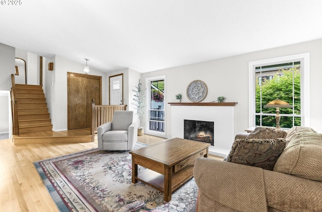 767 SW 8th St, Gresham, OR 97080 - living room with light wood-style flooring, healthy amount of natural light, a lit fireplace, stairway, and lofted ceiling