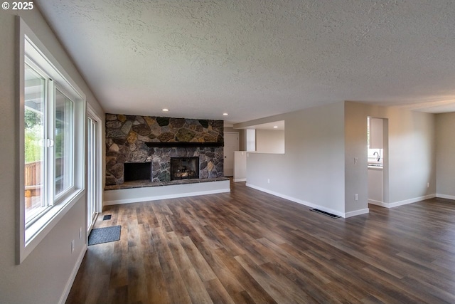 12190 SW Merestone Ct, Tigard, OR 97223 - unfurnished living room featuring a textured ceiling, plenty of natural light, dark wood-style floors, baseboards, and recessed lighting