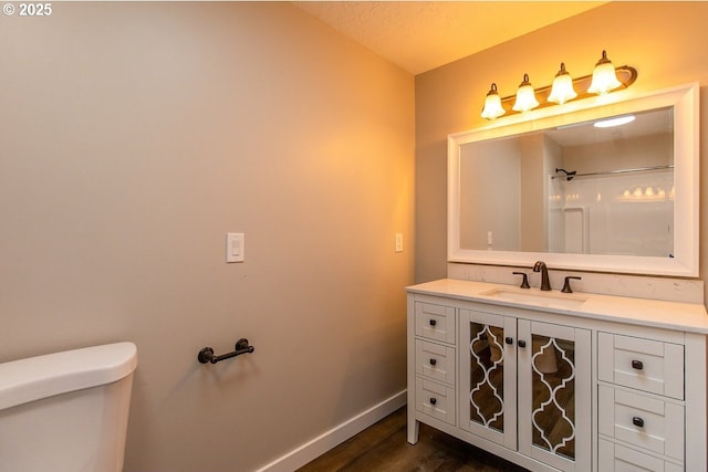 12190 SW Merestone Ct, Tigard, OR 97223 - bathroom with vanity, wood finished floors, baseboards, toilet, and a shower