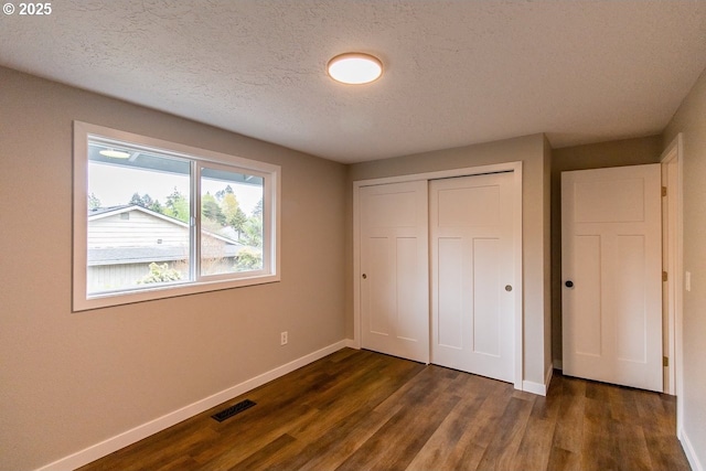 12190 SW Merestone Ct, Tigard, OR 97223 - unfurnished bedroom featuring baseboards, dark wood-style flooring, a textured ceiling, and a closet