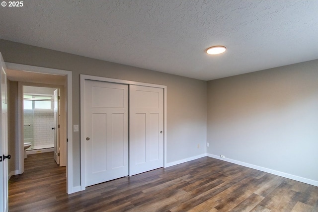 12190 SW Merestone Ct, Tigard, OR 97223 - unfurnished bedroom with dark wood-style flooring, baseboards, a closet, and a textured ceiling