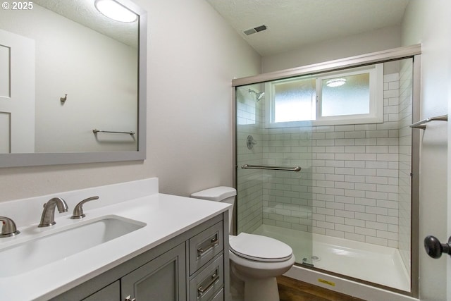 12190 SW Merestone Ct, Tigard, OR 97223 - full bathroom with a stall shower, vanity, toilet, a textured ceiling, and wood finished floors