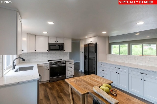 12190 SW Merestone Ct, Tigard, OR 97223 - kitchen featuring black appliances, a sink, tasteful backsplash, white cabinetry, and light stone counters