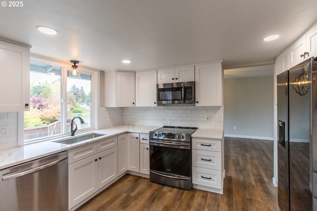 12190 SW Merestone Ct, Tigard, OR 97223 - kitchen with stainless steel appliances, a sink, dark wood finished floors, white cabinetry, and light stone countertops