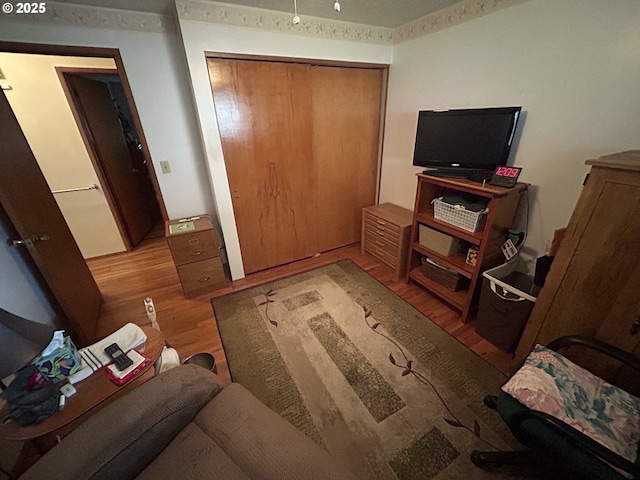 bedroom with light wood-type flooring and a closet