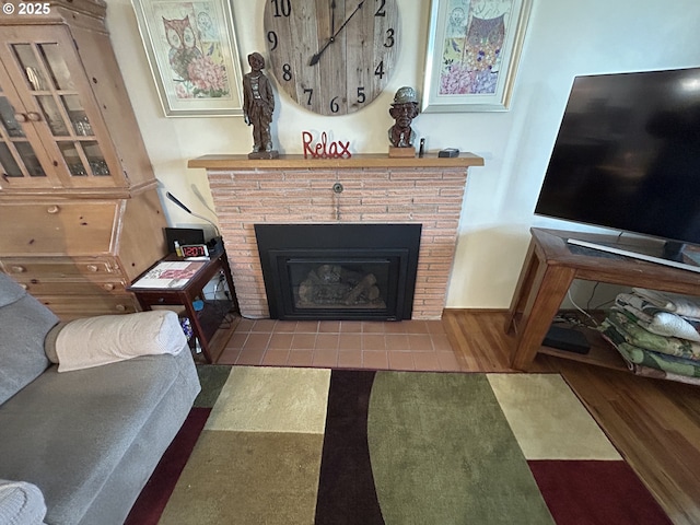 living room featuring a brick fireplace and hardwood / wood-style floors