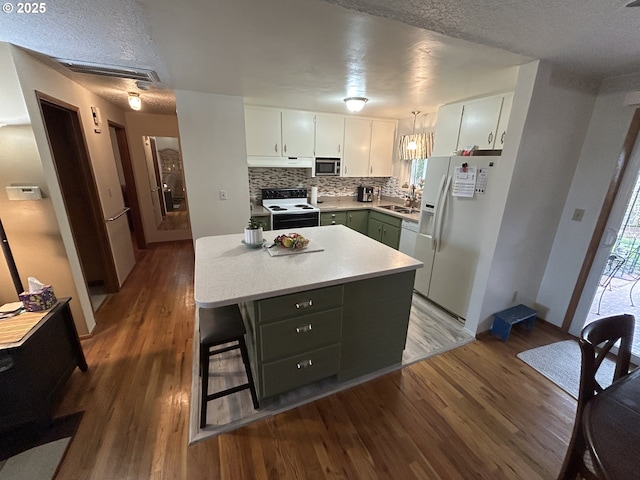 kitchen with range with electric cooktop, white cabinets, hanging light fixtures, a center island, and white fridge with ice dispenser