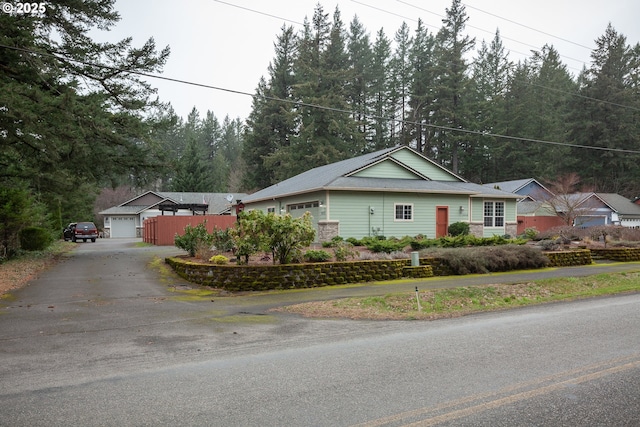 view of front of property with a garage, an outdoor structure, and fence