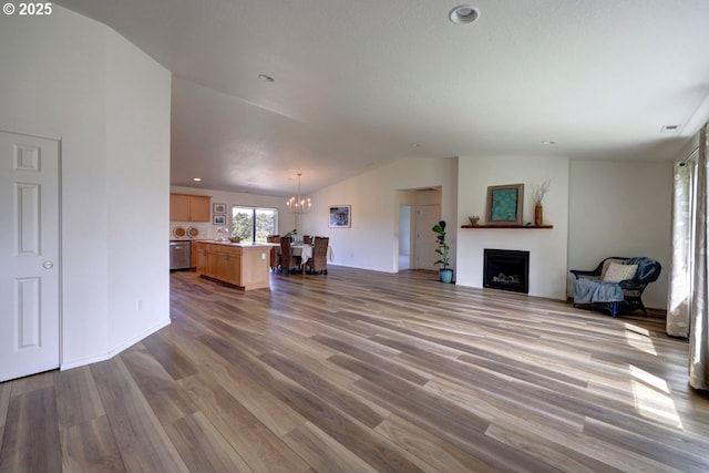 89650 Sea Breeze Dr, Warrenton, OR 97146 - unfurnished living room featuring vaulted ceiling, a chandelier, wood finished floors, a fireplace, and recessed lighting