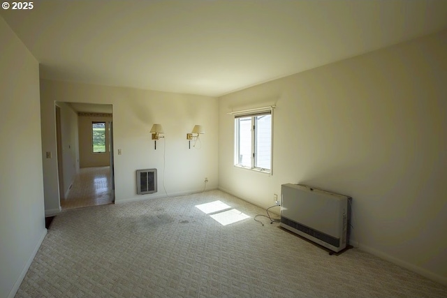 unfurnished living room featuring plenty of natural light, heating unit, and carpet floors