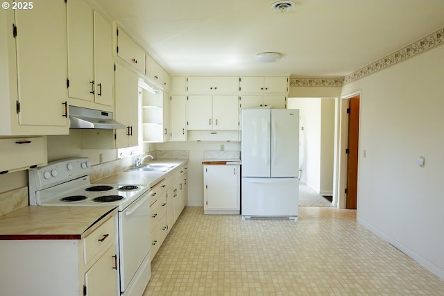 kitchen with a sink, white appliances, light countertops, baseboards, and under cabinet range hood