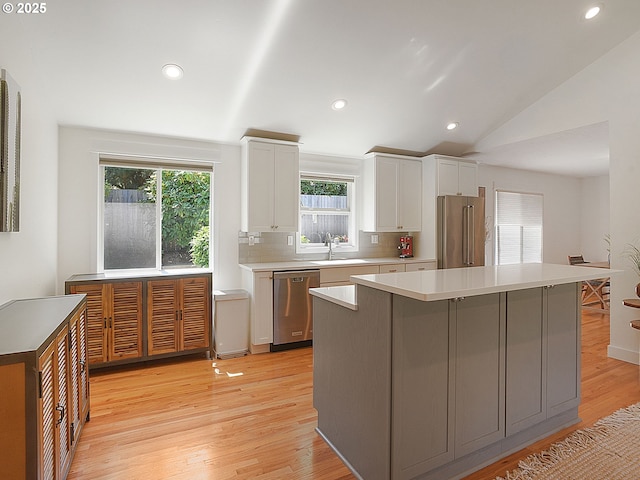 1720 Kilkenny Dr, Lake Oswego, OR 97034 - kitchen featuring stainless steel appliances, white cabinets, a center island, light wood-type flooring, and light countertops