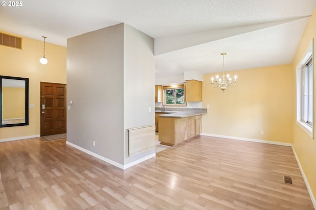4621 SW Caldew St Unit D, Portland, OR 97219 - unfurnished living room with light wood-type flooring, plenty of natural light, and a chandelier