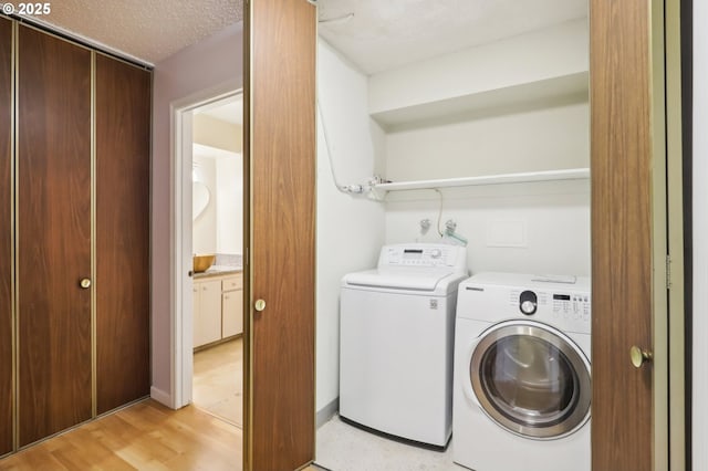 4621 SW Caldew St Unit D, Portland, OR 97219 - laundry room featuring washer and clothes dryer and light wood-type flooring