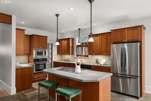 1620 NE Going St, Portland, OR 97211 - kitchen featuring appliances with stainless steel finishes, a kitchen island, decorative backsplash, brown cabinets, and decorative light fixtures