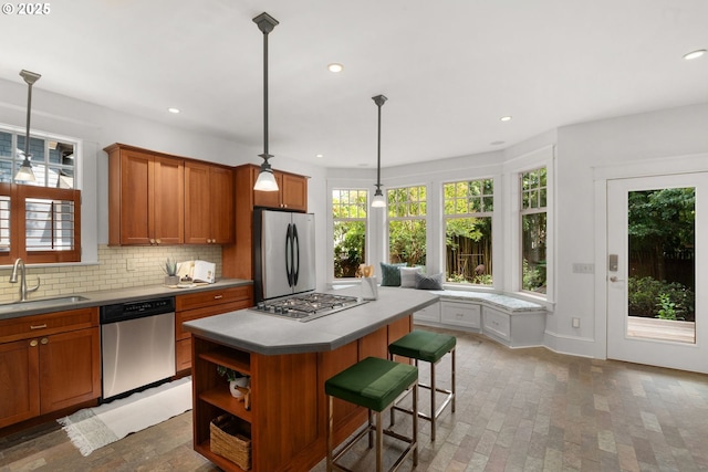 1620 NE Going St, Portland, OR 97211 - kitchen with appliances with stainless steel finishes, brown cabinets, plenty of natural light, tasteful backsplash, and recessed lighting
