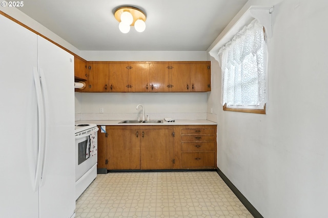 12130 SE Reedway St, Portland, OR 97266 - kitchen with white appliances, light floors, light countertops, and brown cabinets