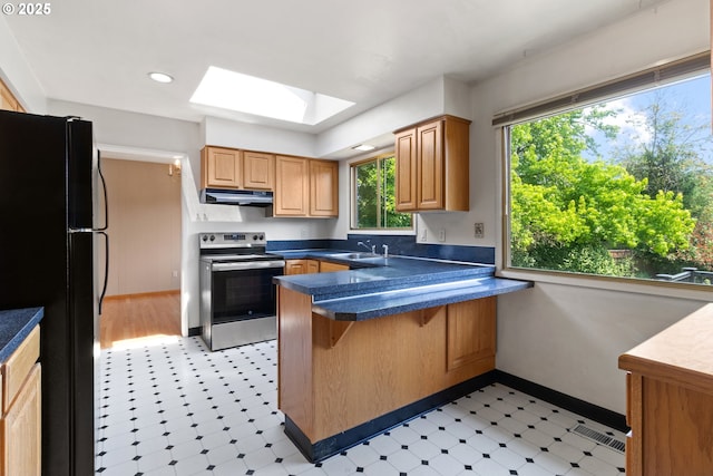 3602 NE 134th Ave, Portland, OR 97230 - kitchen with stainless steel range with electric stovetop, freestanding refrigerator, under cabinet range hood, a skylight, and light flooring