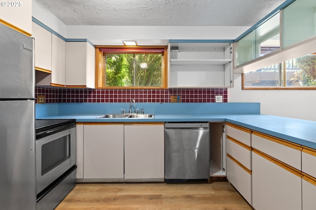 3602 NE 134th Ave, Portland, OR 97230 - kitchen featuring appliances with stainless steel finishes, light wood-style flooring, white cabinetry, decorative backsplash, and light countertops