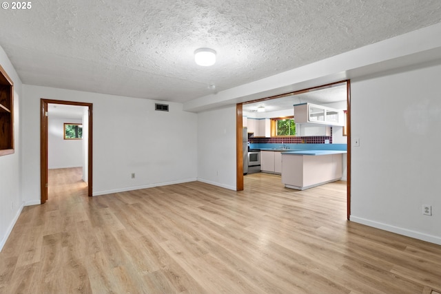 3602 NE 134th Ave, Portland, OR 97230 - unfurnished living room featuring a textured ceiling and light wood-style floors