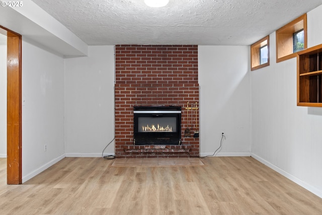 3602 NE 134th Ave, Portland, OR 97230 - unfurnished living room with wood finished floors, a brick fireplace, and a textured ceiling