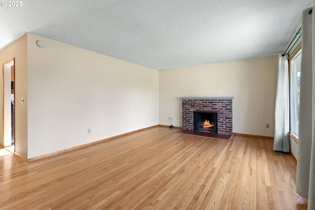 3602 NE 134th Ave, Portland, OR 97230 - unfurnished living room with light wood finished floors and a brick fireplace