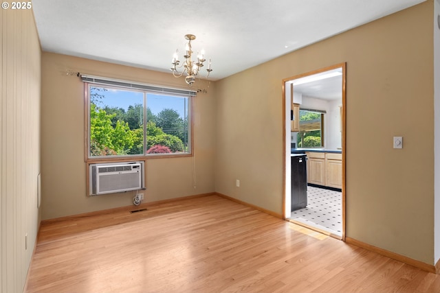 3602 NE 134th Ave, Portland, OR 97230 - empty room with a chandelier, light wood-style floors, and a wall mounted air conditioner
