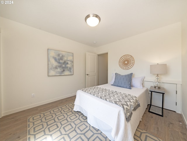 bedroom with wood finished floors and baseboards