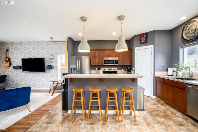 976 E 15th St, Lafayette, OR 97127 - kitchen featuring stainless steel appliances, light countertops, open floor plan, a breakfast bar area, and decorative light fixtures